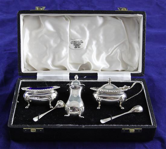 A cased 1960s silver three piece condiment set with two spoons,